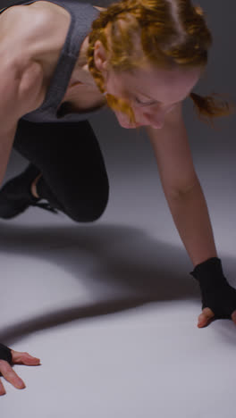 Vertical-Video-Studio-Shot-Of-Mature-Woman-Wearing-Gym-Fitness-Clothing-Doing-Mountain-Climber-Exercise-2